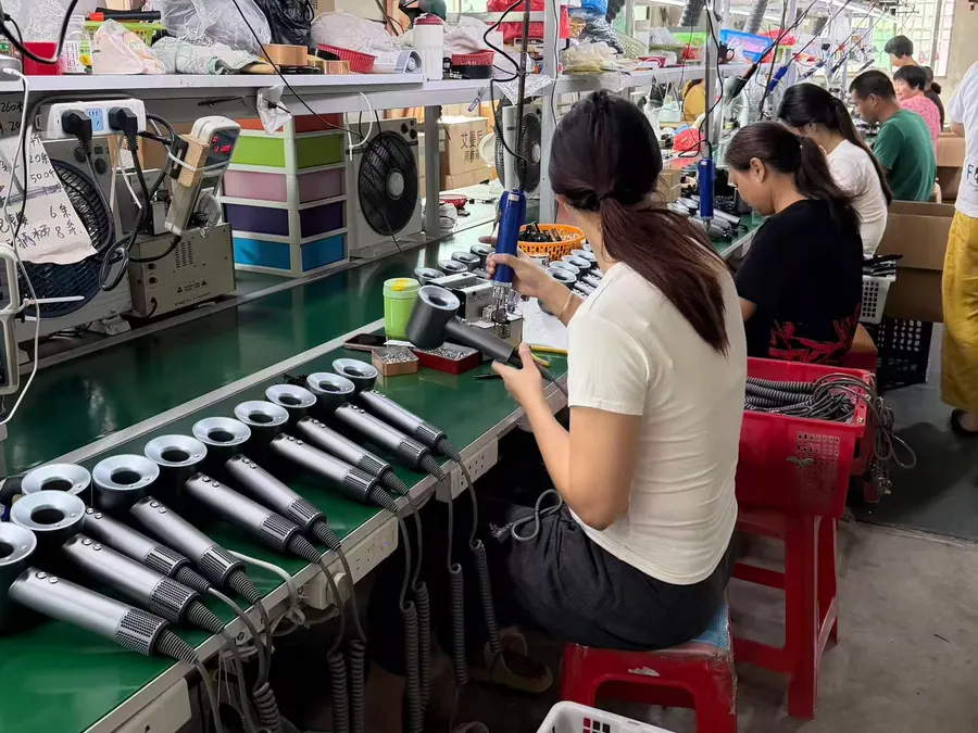 Workers assembling hotel hair dryers on the ShanFlow production line