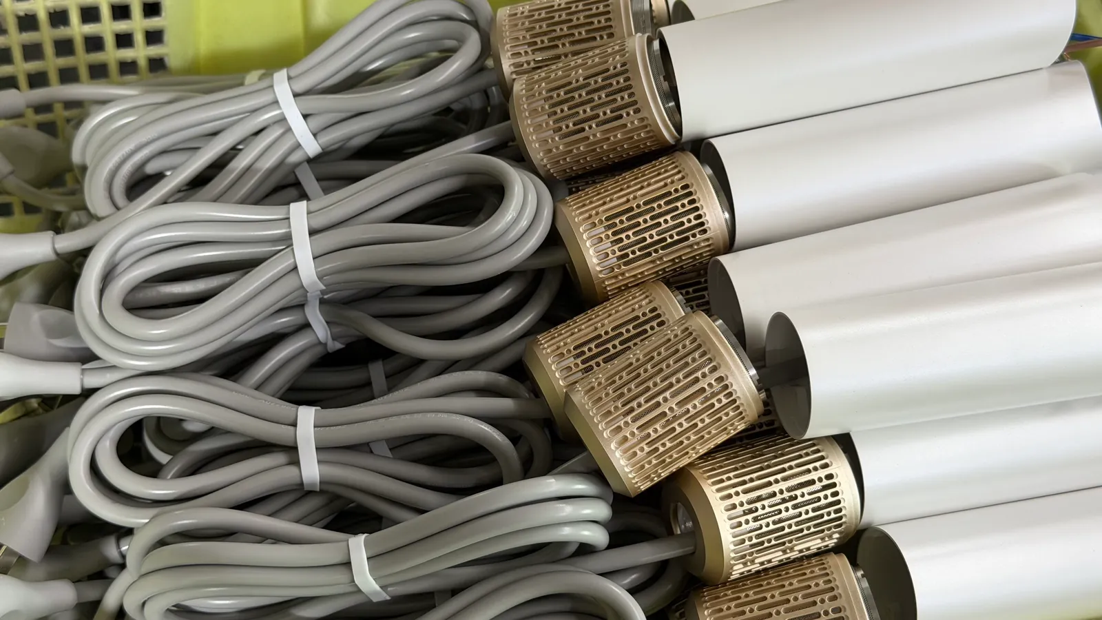 Close-up of high-speed hotel hair dryer handle inlets with metal mesh covers and coiled cords