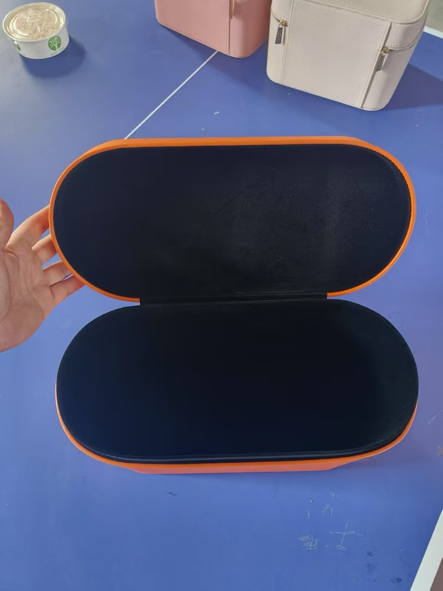 Open orange PU leather hotel hair dryer storage box with a black velvet interior